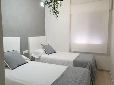 a room with two beds and a window at Las Antillas by RentCadiz in El Puerto de Santa María