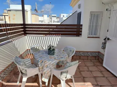 a patio with a table and chairs on a balcony at Mina42 by 7Escalones in Rota