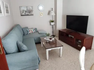 a living room with a blue couch and a tv at Mina42 by 7Escalones in Rota