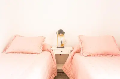 a bedroom with two beds and a nightstand at Carril San Diego, junto a la Plaza Cabildo in Sanlúcar de Barrameda