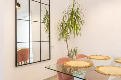 a dining room with a table and chairs and a mirror at Carril San Diego, junto a la Plaza Cabildo in Sanlúcar de Barrameda