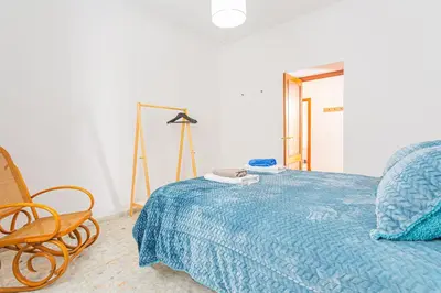 a bedroom with a bed and a chair and a mirror at Carril San Diego, junto a la Plaza Cabildo in Sanlúcar de Barrameda