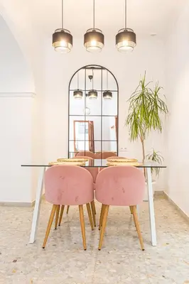 a dining room table with two pink chairs at Carril San Diego, junto a la Plaza Cabildo in Sanlúcar de Barrameda