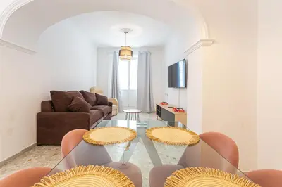 a living room with a glass table and chairs at Carril San Diego, junto a la Plaza Cabildo in Sanlúcar de Barrameda