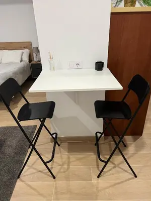 a white table and two chairs in a room with a bed at Apartamento Porvenir in Jerez de la Frontera