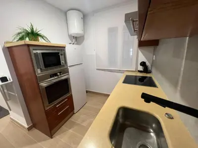a small kitchen with a sink and a microwave at Apartamento Porvenir in Jerez de la Frontera