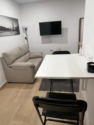 a living room with a white table and a couch at Apartamento Porvenir in Jerez de la Frontera