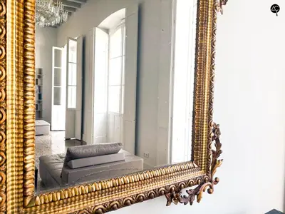 a mirror on a wall with a couch in a room at Casa Plaza Candelaria Cádiz Grupo AC Gestión in Cádiz