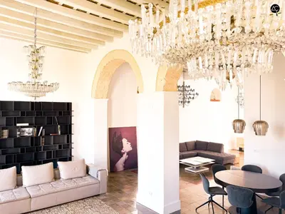 a living room with chandeliers and a table at Casa Plaza Candelaria Cádiz Grupo AC Gestión in Cádiz