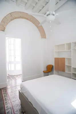 a white bedroom with a bed and a ceiling at Casa Plaza Candelaria Cádiz Grupo AC Gestión in Cádiz