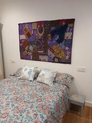 a bed with pillows and a painting on the wall at Residencial Golf jerez in Jerez de la Frontera
