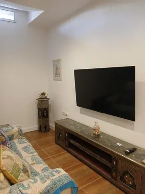 a living room with a large flat screen tv on the wall at Residencial Golf jerez in Jerez de la Frontera