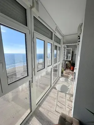 a room with windows and a view of the ocean at ARENA y Mar Sunny Home by Cadiz4Rentals in Cádiz
