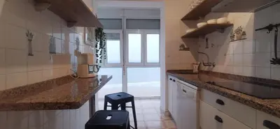 a kitchen with a counter and a stool in it at ARENA y Mar Sunny Home by Cadiz4Rentals in Cádiz