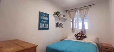 a bedroom with a bed and a sign on the wall at ARENA y Mar Sunny Home by Cadiz4Rentals in Cádiz