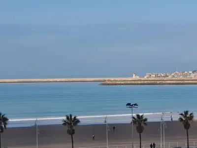 a beach with palm trees and a body of water at Valdelagrana Marinero in El Puerto de Santa María
