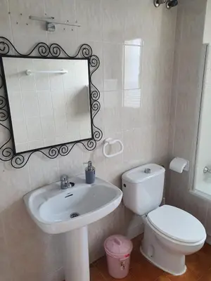 a bathroom with a sink and a toilet and a mirror at Valdelagrana Marinero in El Puerto de Santa María