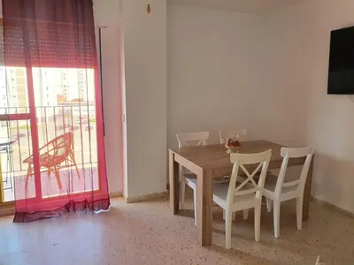 a dining room table and chairs with a table and a window at Valdelagrana Marinero in El Puerto de Santa María