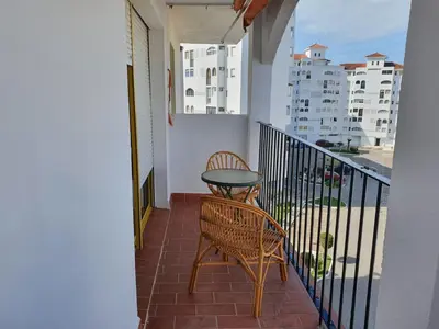 a balcony with a table and chairs on a balcony at Valdelagrana Marinero in El Puerto de Santa María