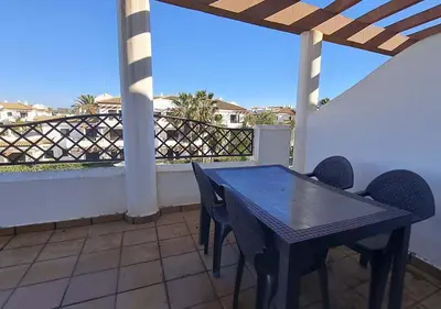 a table and chairs on a balcony with a view at Segunda planta con terraza y solarium in Chiclana de la Frontera