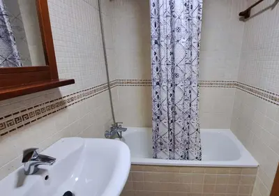 a bathroom with a sink and a shower curtain at Segunda planta con terraza y solarium in Chiclana de la Frontera