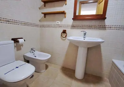 a bathroom with a toilet and a sink at Segunda planta con terraza y solarium in Chiclana de la Frontera
