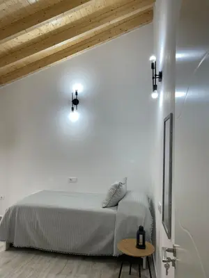 a white bedroom with a bed and a table at Casa Delia in Bornos
