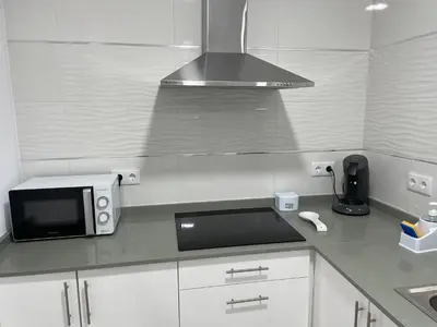 a white kitchen with a microwave and a sink at Casa Delia in Bornos