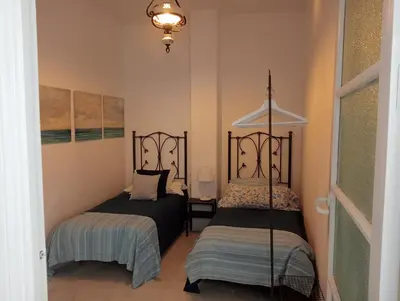 a bedroom with two beds and a lamp at Casa Palacio Madre de la Eucaristía in El Puerto de Santa María