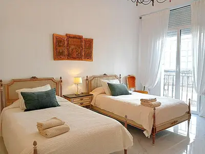 two beds sitting next to each other in a bedroom at Casa Palacio Madre de la Eucaristía in El Puerto de Santa María