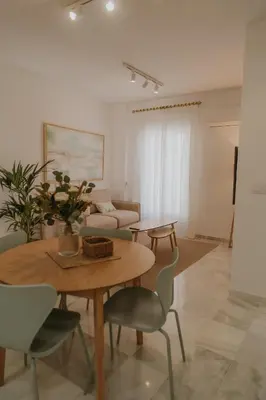 a living room with a table and chairs and a couch at Apartamento El Mazacote Sanlúcar de Barrameda in Sanlúcar de Barrameda