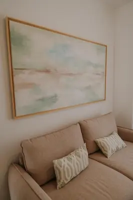 a painting above a couch in a living room at Apartamento El Mazacote Sanlúcar de Barrameda in Sanlúcar de Barrameda