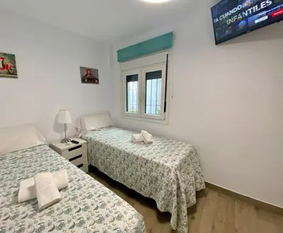 two beds sitting next to each other in a bedroom at Moderno Apartamento Primera Línea Playa de La Barrosa by ChiclanaDreams in Chiclana de la Frontera