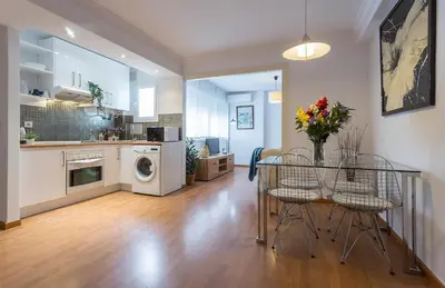 a kitchen and dining room with a table with flowers on it at Centrico Tranquilo 2 Rooms in Jerez de la Frontera