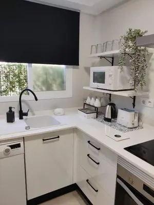 a white kitchen with a sink and a microwave at Oloroso Home CERCA CENTRO in Jerez de la Frontera