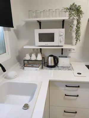 a white kitchen with a microwave and a sink at Oloroso Home CERCA CENTRO in Jerez de la Frontera