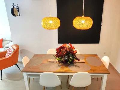 a dining room table with white chairs and two lights at Oloroso Home CERCA CENTRO in Jerez de la Frontera