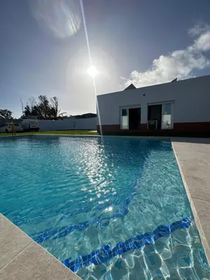 a swimming pool in front of a house at Villa Luna Novo Santi Petri in Chiclana de la Frontera
