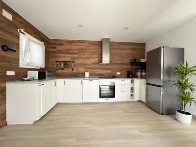 a kitchen with white cabinets and a stainless steel refrigerator at Villa Luna Novo Santi Petri in Chiclana de la Frontera