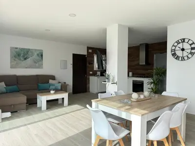 a kitchen and living room with a table and chairs at Villa Luna Novo Santi Petri in Chiclana de la Frontera
