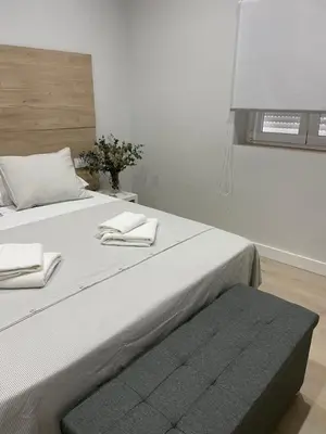a bedroom with a large bed with two towels on it at Apartamentos Corredera 3 in Arcos de la Frontera