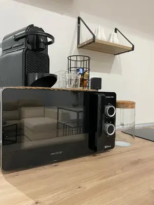 a black microwave sitting on a kitchen floor at Apartamentos Corredera 3 in Arcos de la Frontera