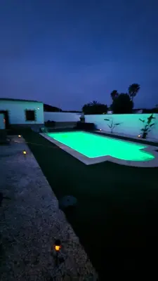 a green swimming pool at night with a building at Villas Luins in Chiclana de la Frontera