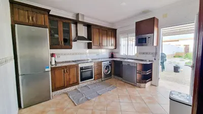 a kitchen with wooden cabinets and a stainless steel refrigerator at Villas Luins in Chiclana de la Frontera