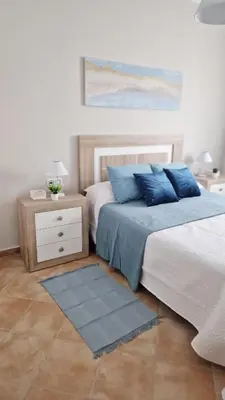 a bedroom with two beds with blue pillows at Villas Luins in Chiclana de la Frontera