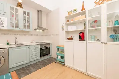 a kitchen with white cabinets and a sink at Starlight in Cádiz