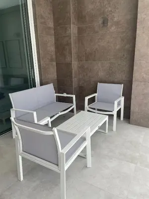 two white chairs and a bench on a patio at Costa Ballena - Dos dormitorios, Piscina y Jardín privado in Cádiz