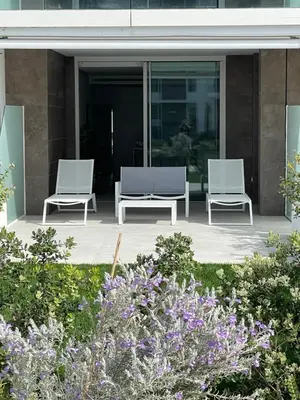 two chairs sitting on a patio in front of a building at Costa Ballena - Dos dormitorios, Piscina y Jardín privado in Cádiz
