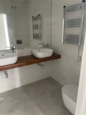a white bathroom with a sink and a toilet at Costa Ballena - Dos dormitorios, Piscina y Jardín privado in Cádiz