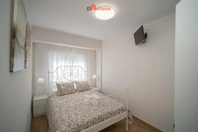 a bedroom with a bed in a white room at El Anfitrión - Carmen Viejo in Sanlúcar de Barrameda
